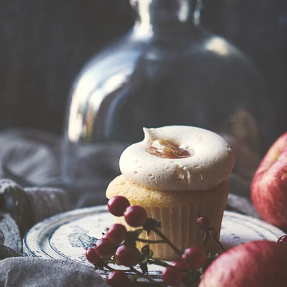 A frosted cupcake on a rustic plate